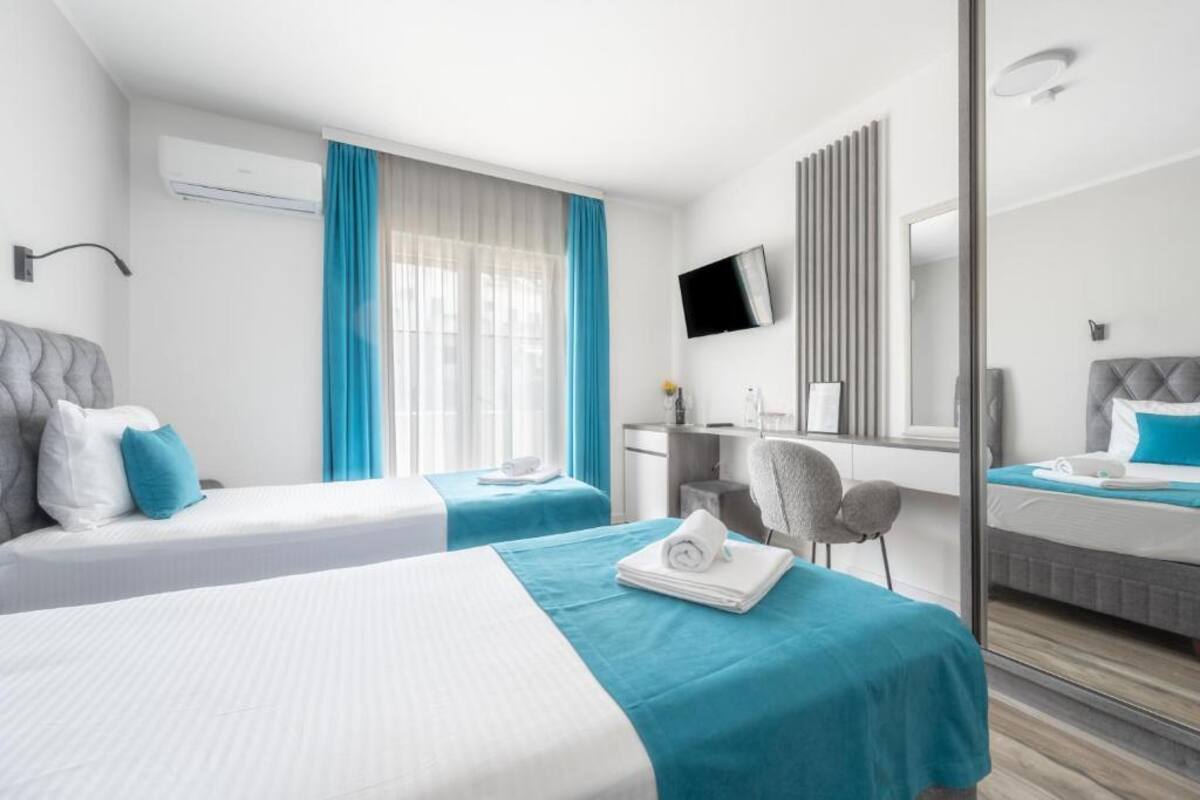 Twin room at Hotel Mondo with desk and mirrored wardrobe