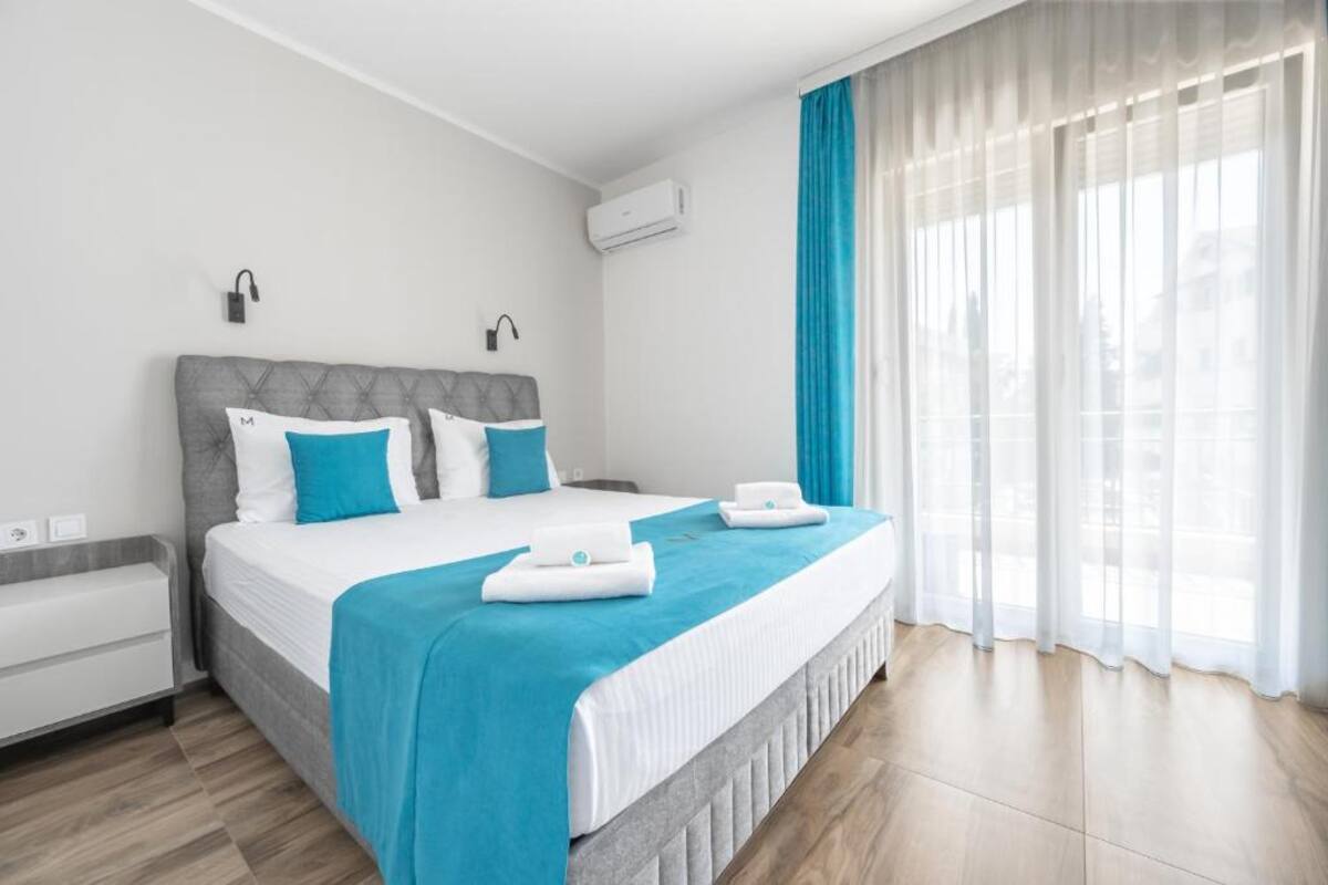 Double room at Hotel Mondo with grey bed and turquoise accents